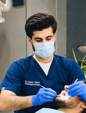 Dr. Izhar Khan, Periodontologist at Medicube Clinics, treating a patient